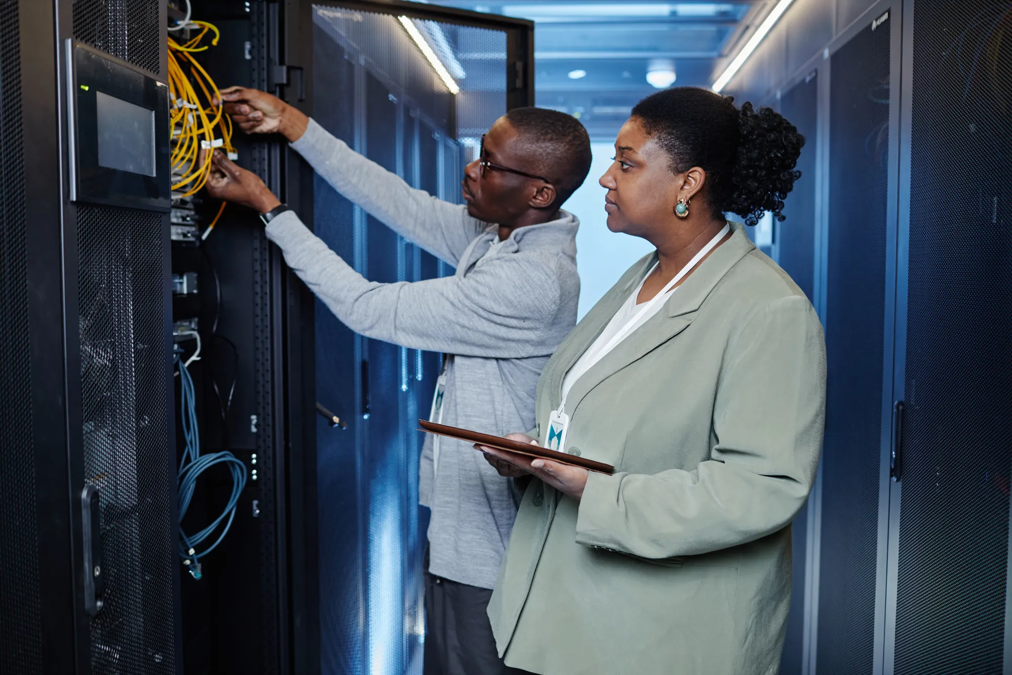 Two engineers working together at a server rack